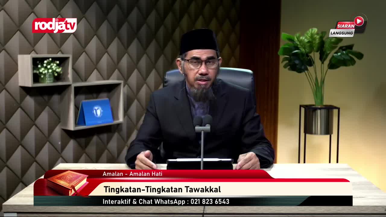 A man in a black suit and cap speaks into two microphones, likely on Rodja TV in Indonesia. Below, a graphic displays the program's title, "Tingkatan-Tingkatan Tawakkal," and a phone number for viewers.
