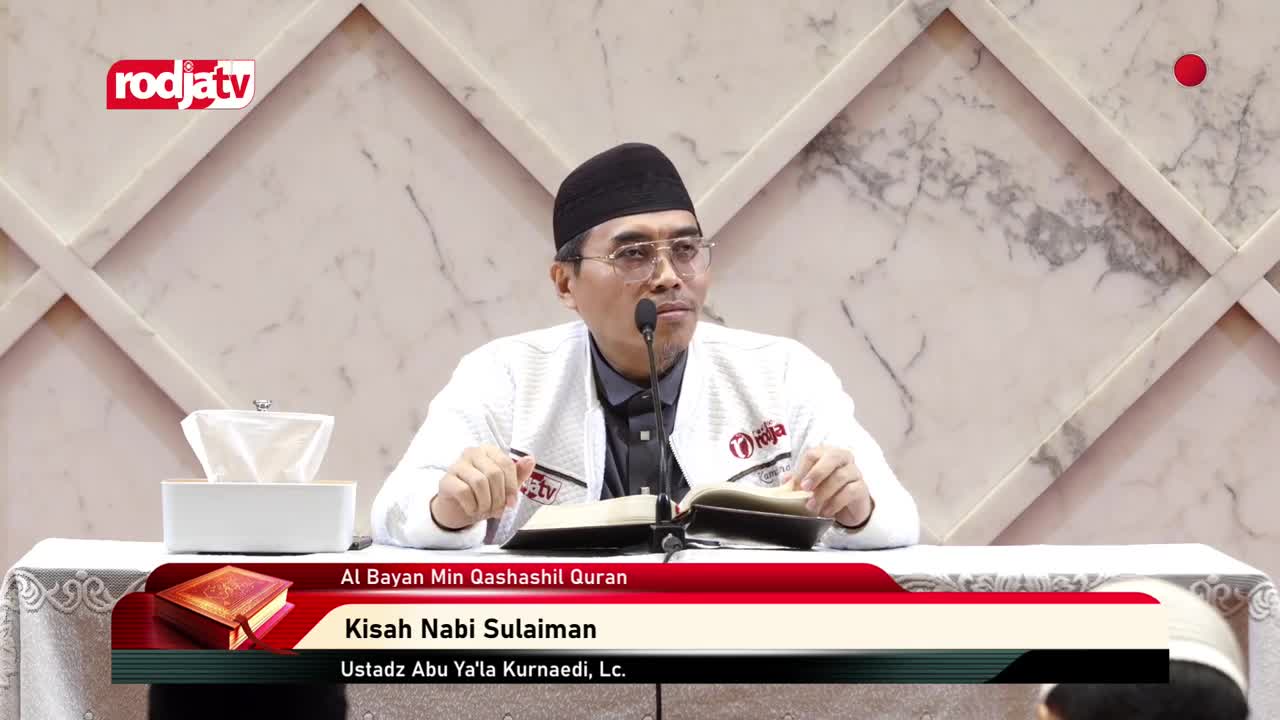 A man in a black cap and glasses speaks into a microphone, gesturing with a pen as he reads from a book. The Rodja TV logo is visible in the top left, and a title banner below identifies the topic as "Kisah Nabi Sulaiman."
