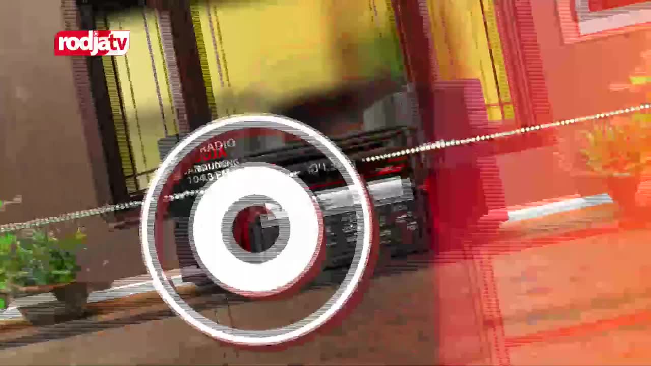 A stylized graphic of a radio and concentric circles overlays a blurred scene, likely from Rodja TV in Indonesia. The design is a mix of red and white, with a suggestion of a room's interior.
