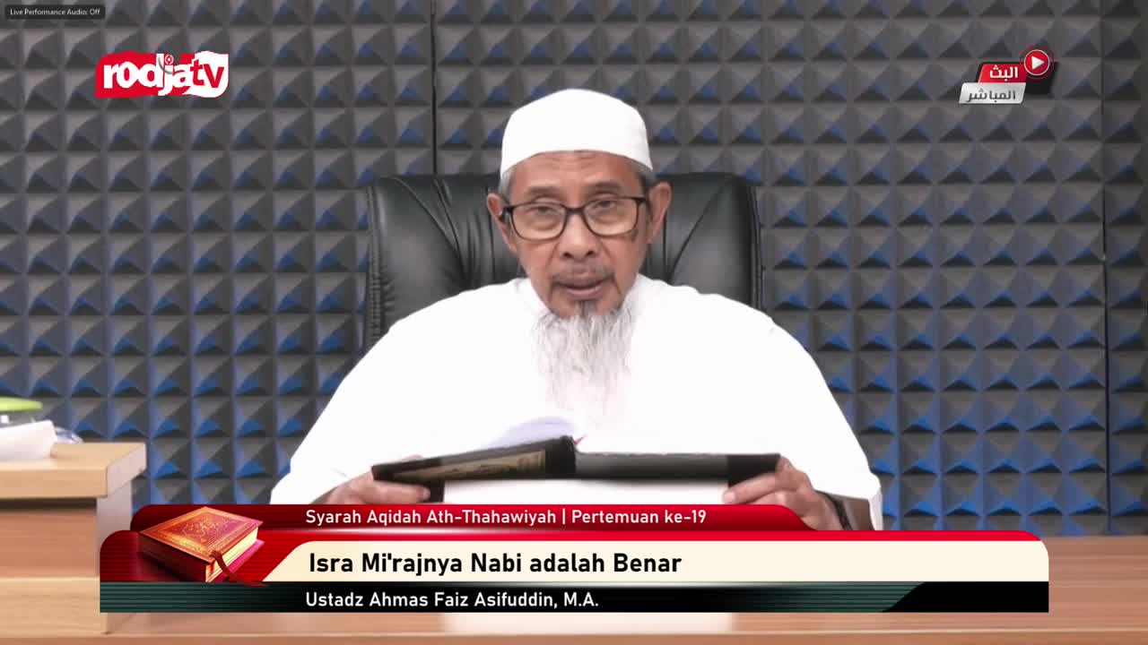 A man in a white peci and robe speaks, holding an open book. The Rodja TV logo appears on screen, indicating a broadcast from Indonesia.
