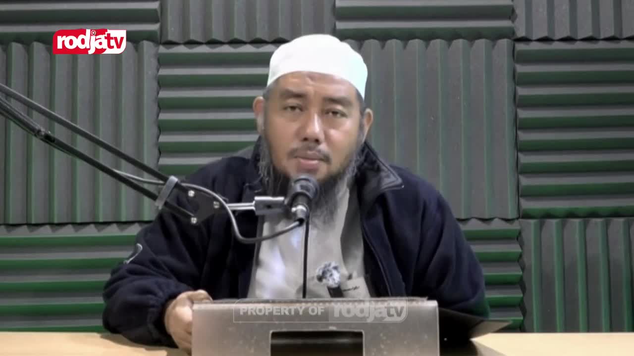 A man with a white peci and a beard speaks into a microphone in front of a sound-dampened wall. The Rodja TV logo is visible on the screen.