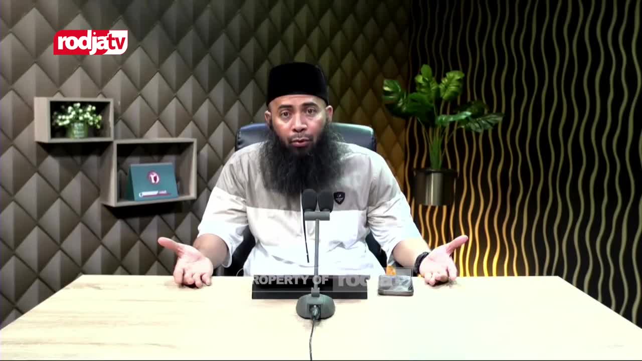 A man with a long beard and a black peci hat speaks animatedly, gesturing with his hands. The Rodja TV logo appears in the corner of the screen.