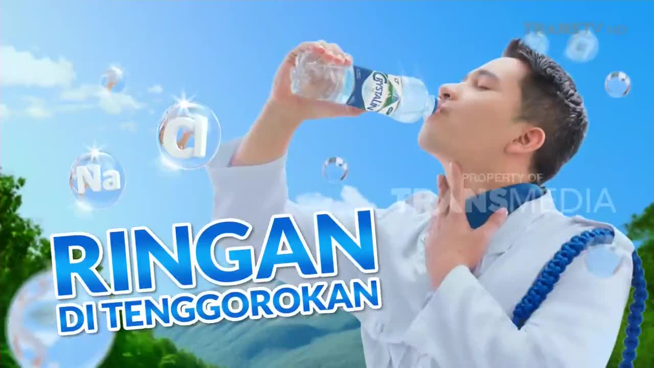 A young man in a white uniform tilts his head back, taking a long drink from a bottle of Crystalin water. Floating bubbles with chemical symbols and a blue banner with Indonesian text complete the ad on Trans TV.
