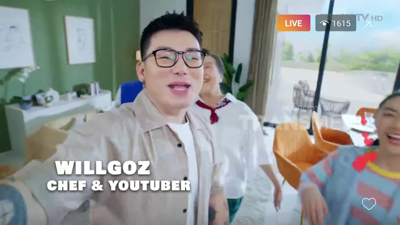 Willgoz, the chef and YouTuber, is holding the camera, talking, while two women happily move into the frame behind him. The scene is live on Trans TV, and the setting appears to be a modern home in Indonesia.
