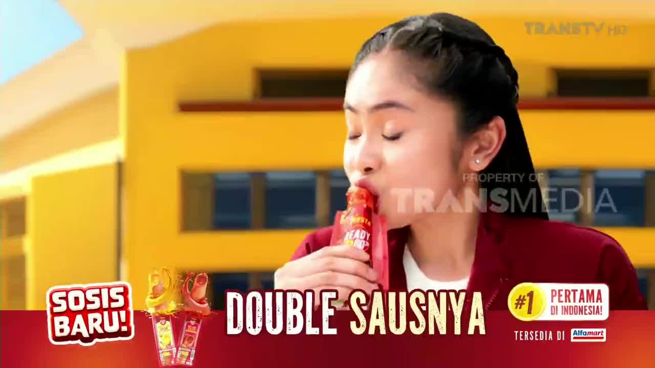 A young woman, framed against a yellow building, is shown drinking from a red packet. The Trans TV logo is visible in the corner, and the graphic reads "Double Sausnya."
