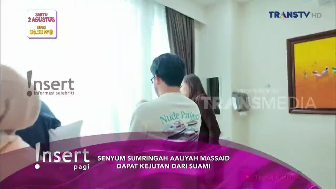 A man in a white t-shirt stands by the window, facing away from the camera. A woman is behind him, and the Insert logo from Trans TV is in the foreground.
