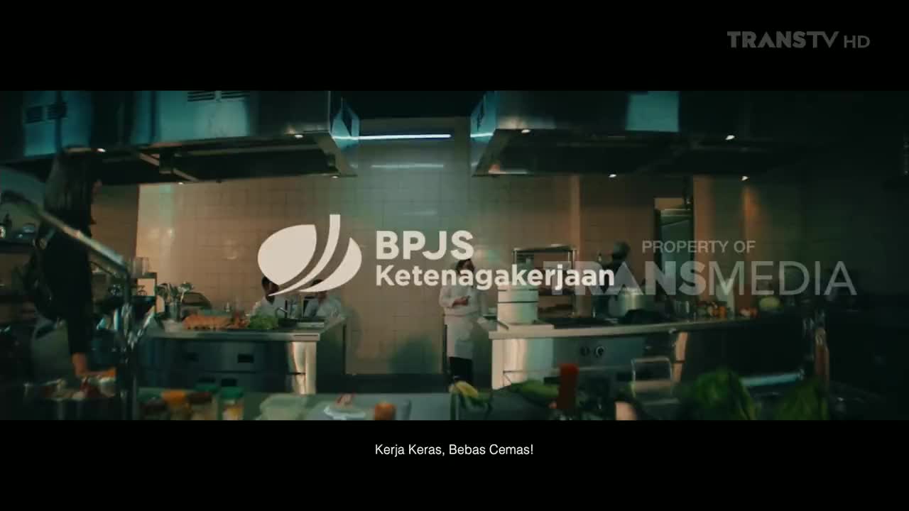 A kitchen crew in white coats works busily under bright lights, with a logo for BPJS Ketenagakerjaan prominently displayed on the screen. The Trans TV HD logo is in the corner.
