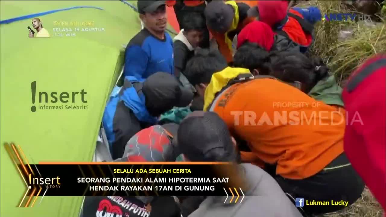 A group of people huddle around someone, possibly inside a tent, on a mountainside. The Trans TV logo indicates this is a news report from Indonesia, likely about a hiker experiencing hypothermia.
