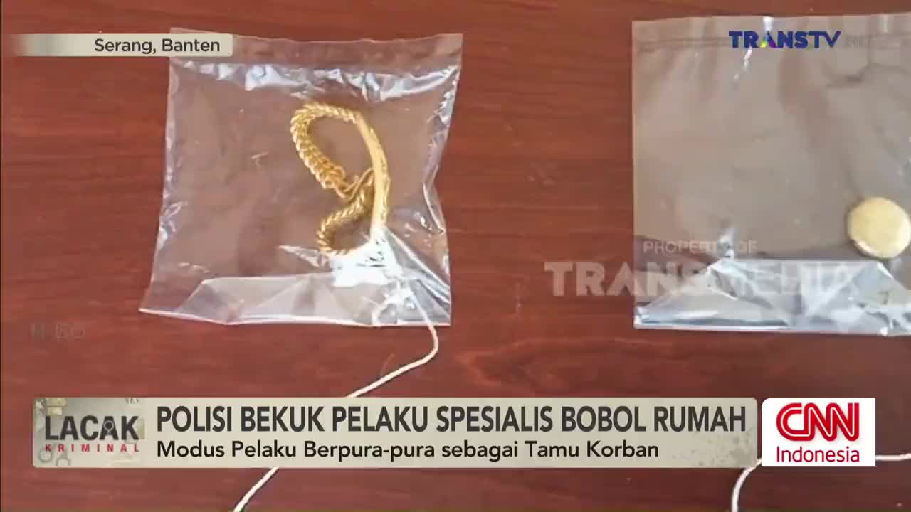 On a wooden surface, two clear plastic bags sit side-by-side; one contains a gold chain. The Trans TV logo is visible in the corner, and the headline discusses a police arrest in Serang, Banten.
