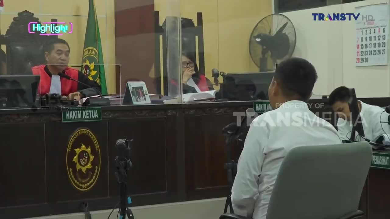 In a courtroom setting, a man in a white shirt sits facing the judge, while the "Hakim Ketua" speaks into a microphone. The Trans TV logo is visible, indicating this is likely a broadcast from Indonesia.
