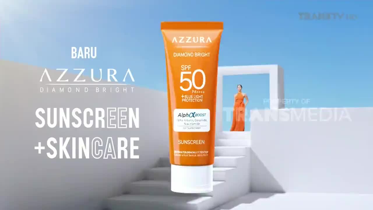 An orange tube of Azzura Diamond Bright sunscreen hovers in front of a white staircase, with a woman in an orange dress standing in the background. The Trans TV logo is visible in the top right corner.

