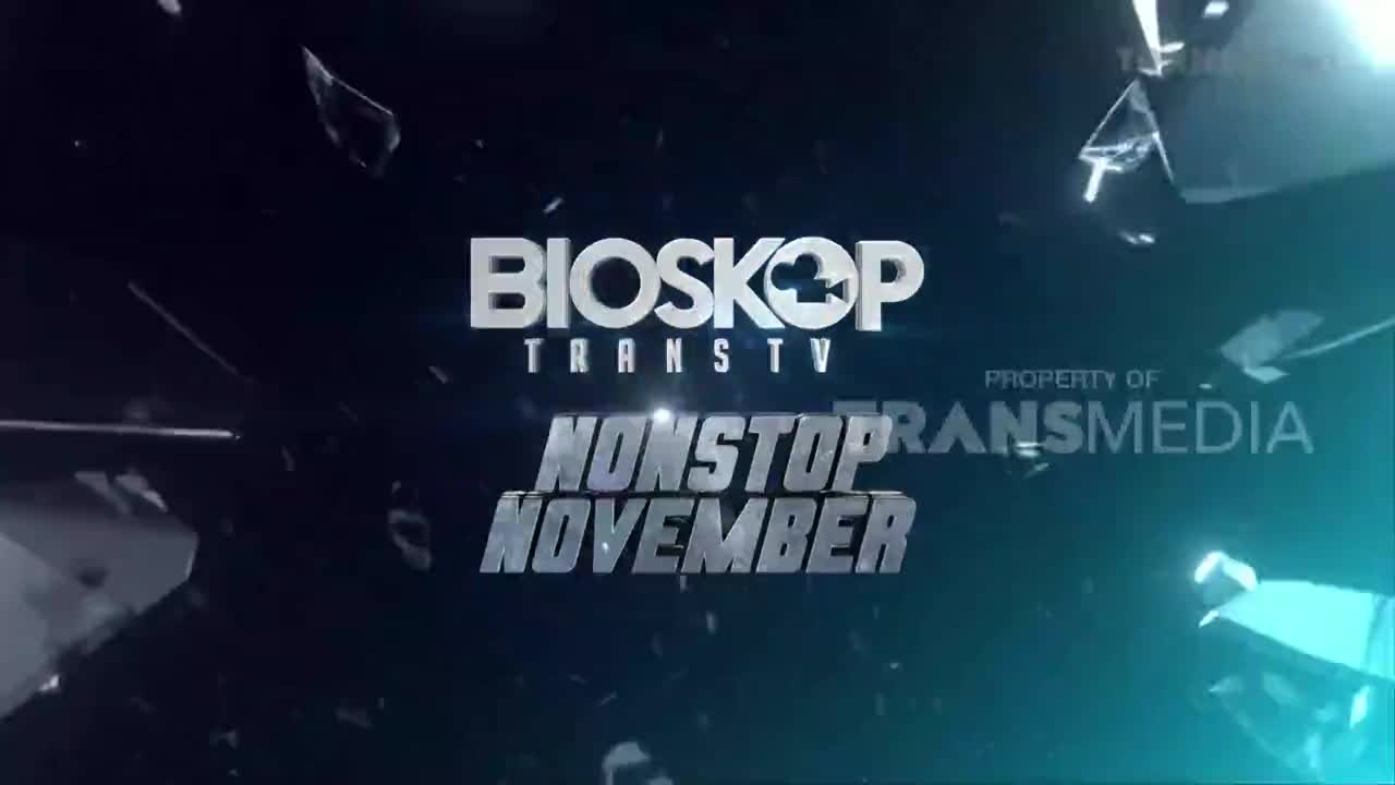 The "Bioskop Trans TV" logo shines brightly, with "Nonstop November" beneath it. Shards of glass appear to be exploding outwards from the center, creating a dramatic effect.
