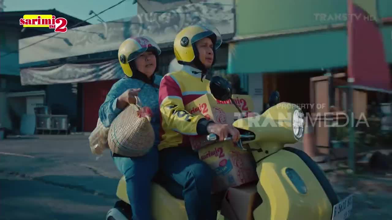 A yellow scooter, carrying two people and boxes of Sarimi noodles, speeds down the street. The scene is part of a Trans TV production, with a "Property of Trans Media" watermark visible.
