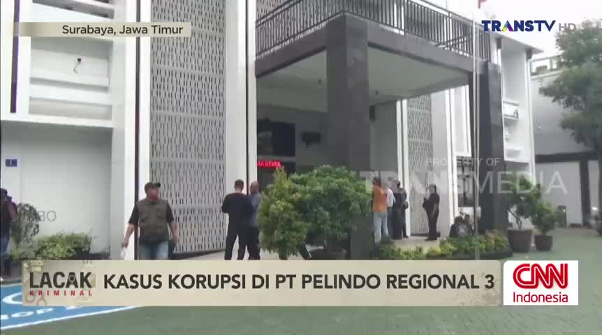 Outside a building in Surabaya, a group of people stand near the entrance, likely discussing the corruption case reported by Trans TV. The CNN Indonesia logo is visible, and the scene is being filmed.
Outside a building in Surabaya, a group of people stand near the entrance, likely discussing the corruption case reported by Trans TV. The CNN Indonesia logo is visible, and the scene is being filmed.
