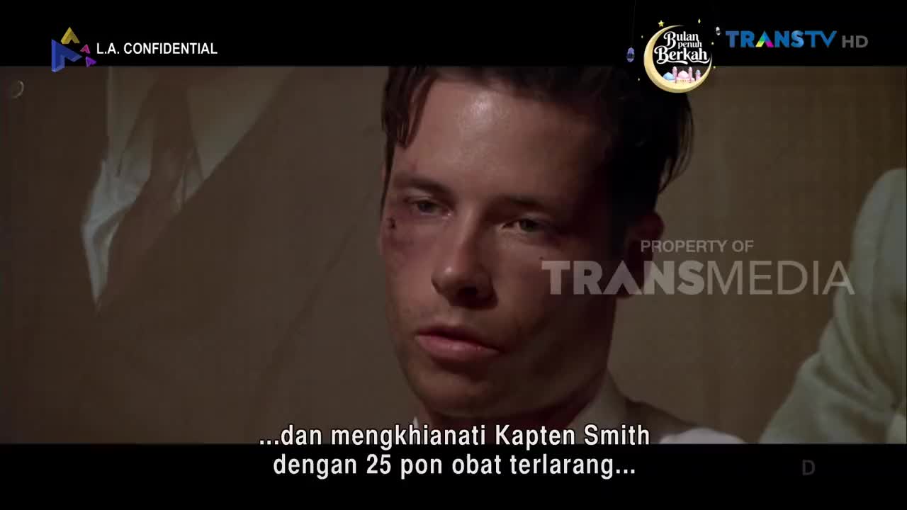 A man with a bruised face looks off to the side, his expression troubled. The Trans TV logo appears on screen, indicating the broadcast is in Indonesia.