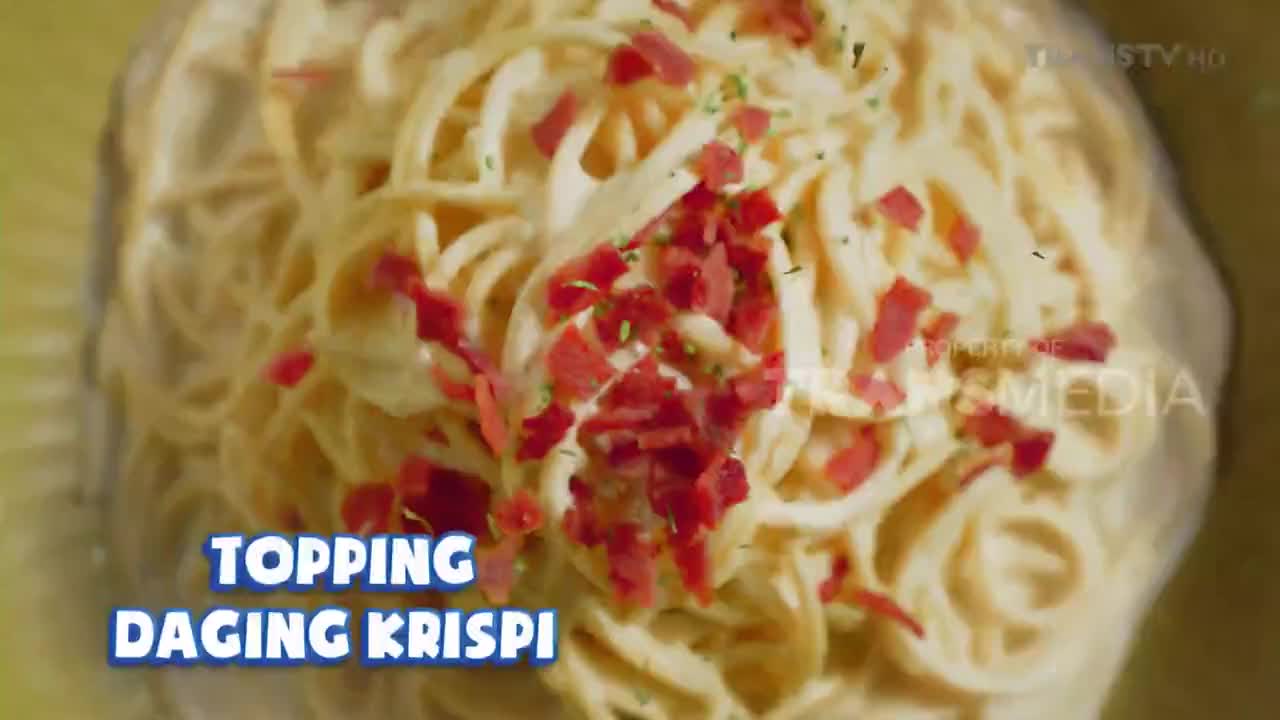 A generous portion of spaghetti, coated in creamy sauce and sprinkled with crispy bacon bits, is presented. The words "TOPPING DAGING KRISPI" flash across the screen, indicating the dish's feature.