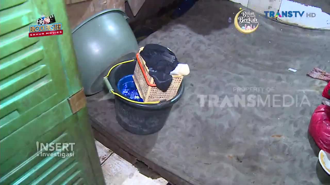 A dark bucket holds a smaller woven basket filled with black clothing. A large green plastic container sits nearby, leaning slightly.