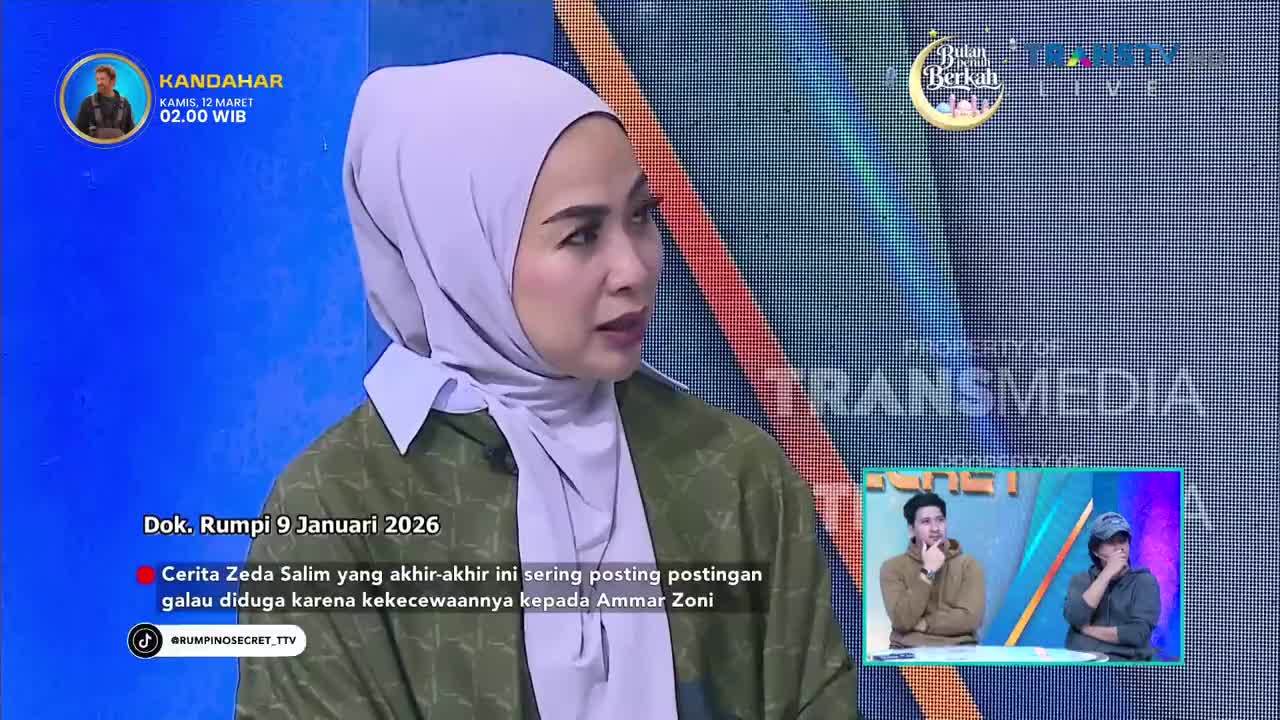 A woman in a light purple hijab speaks intently on a Trans TV program. A smaller screen in the corner shows two men in discussion.