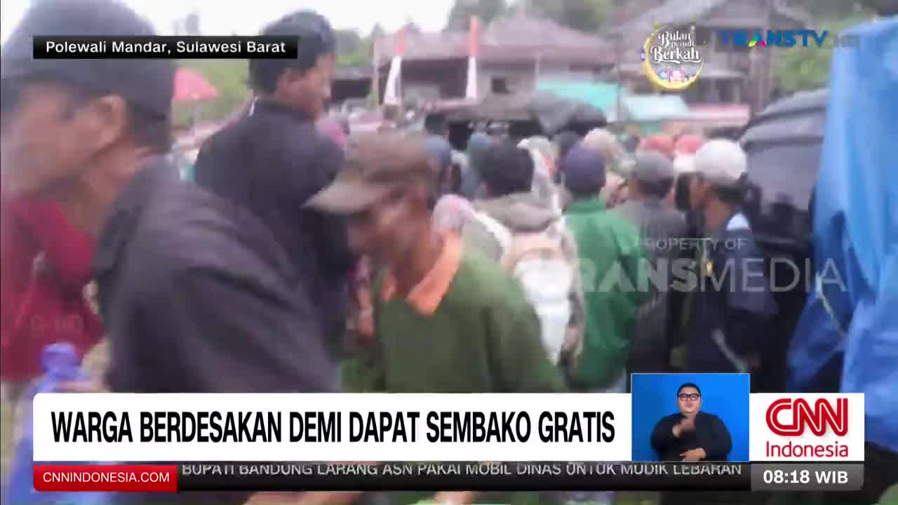 People are packed together, jostling to get closer to the front. A Trans TV crew is filming the scene in Polewali Mandar, Sulawesi Barat.
