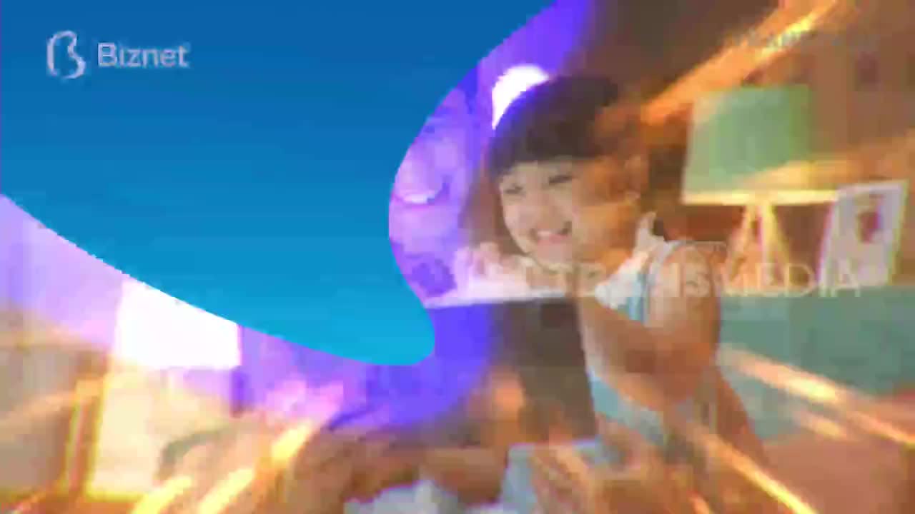 A young girl beams as she holds up a tablet, the Trans TV logo faintly visible. The bright blue and purple graphics suggest a lively broadcast from Indonesia.