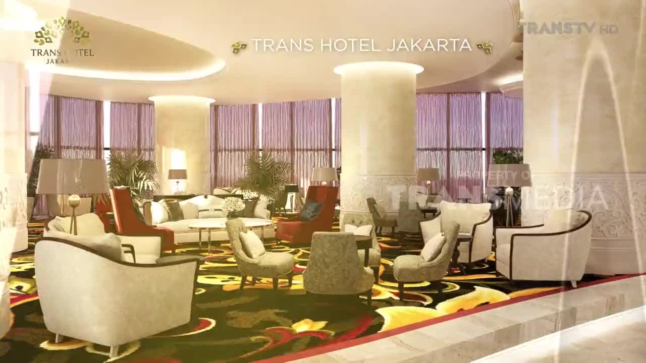 The Trans Hotel Jakarta lobby is bathed in warm light, with plush seating arrangements scattered across a vibrant, patterned carpet. Trans TV's logo is subtly overlaid on the scene.