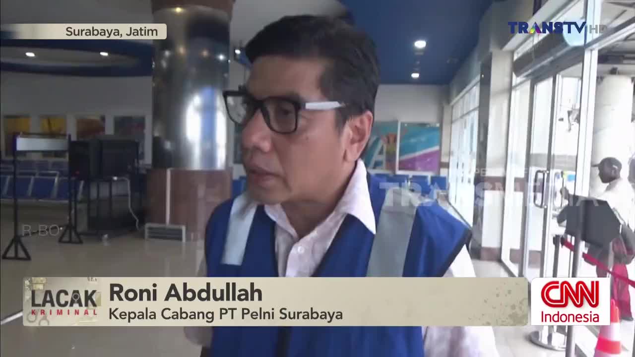 A man in a blue vest speaks to the camera, identifying himself as the branch head of PT Pelni Surabaya. Behind him, a Trans TV logo is visible, and a person in a white shirt enters through glass doors.