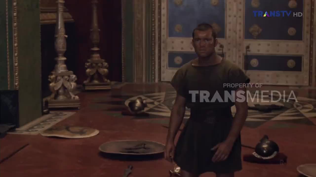 A man in a tunic stands in a grand hall, his gaze fixed forward. Scattered on the floor are helmets and shields, remnants of a recent conflict.