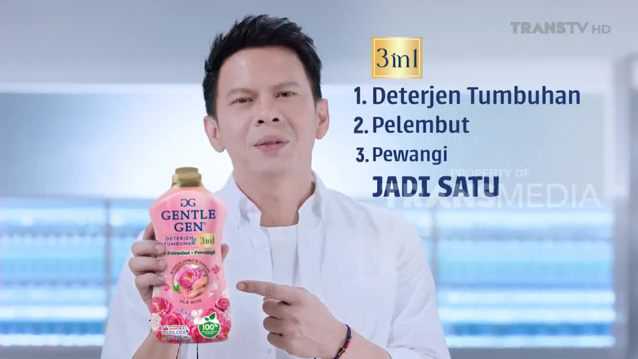 A man holds up a bottle of Gentle Gen detergent, pointing to the text on the screen that lists its three functions. The Trans TV logo is visible in the corner.