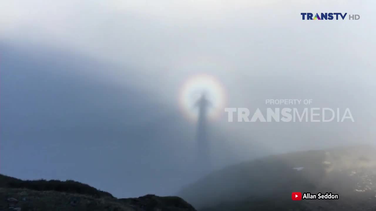 A halo of light surrounds a dark, human-shaped figure in the mist. The Trans TV logo appears in the upper right corner.
