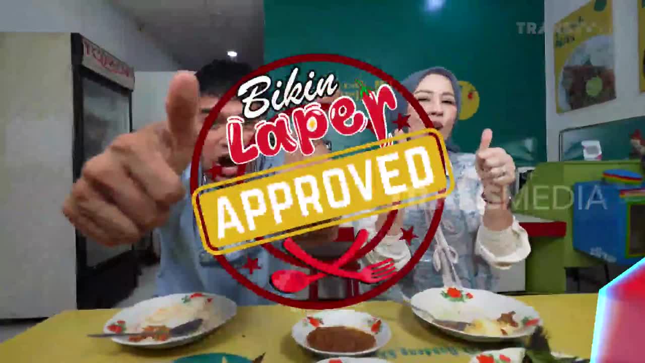 A man and woman give thumbs up as a "Bikin Laper Approved" graphic overlays them. Plates of food sit on a yellow table in front of them.