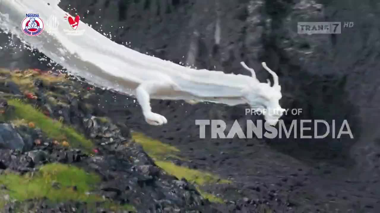 A dragon made of what looks like milk is arcing down the side of a rocky cliff. The Trans7 logo and other branding are visible at the top of the screen.
