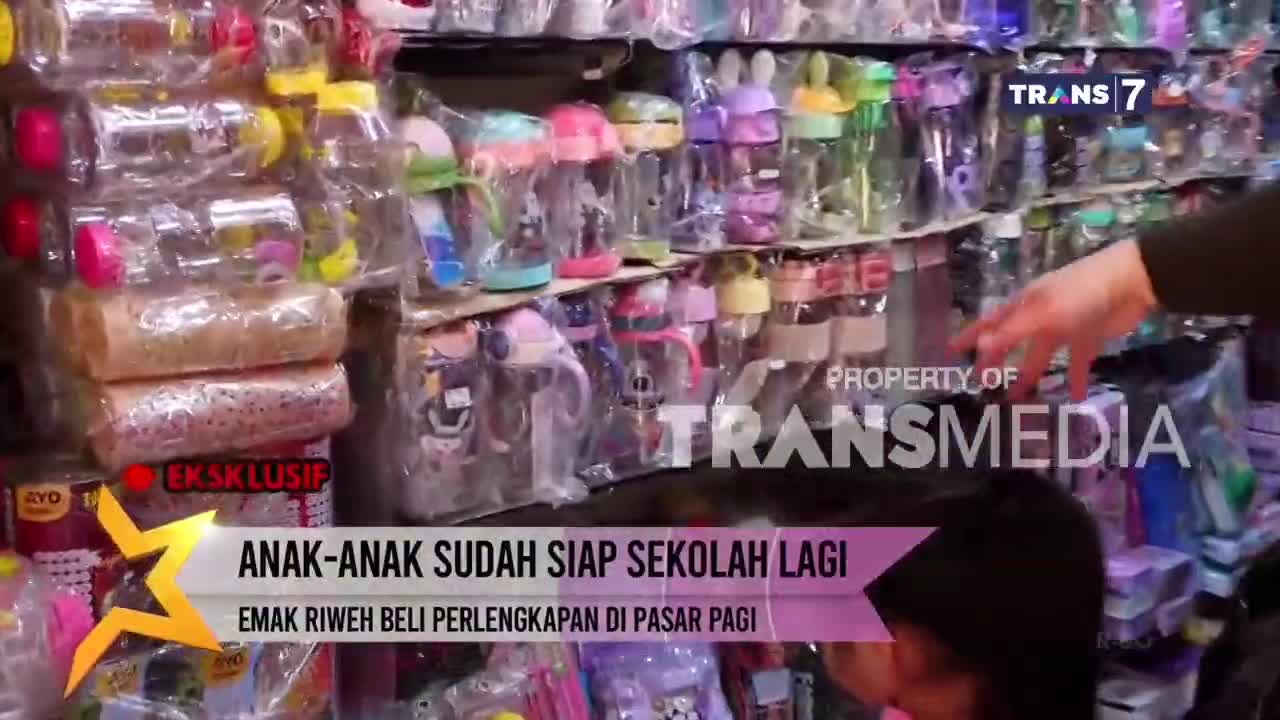 A hand gestures towards a shelf packed with colorful water bottles and sippy cups. The Trans7 logo is visible, and the on-screen text mentions children preparing for school in Indonesia.
