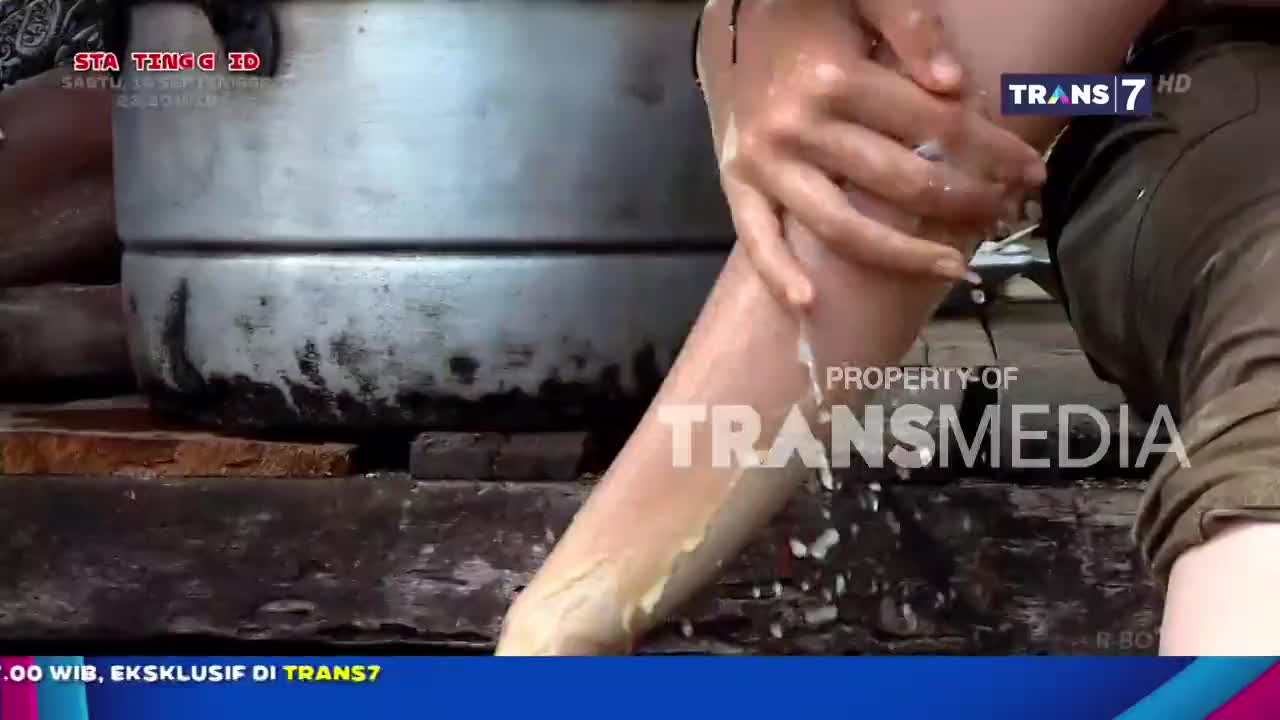 Someone is washing their leg, suds and water cascading down their skin. The scene is captured on Trans7, a television station in Indonesia.
