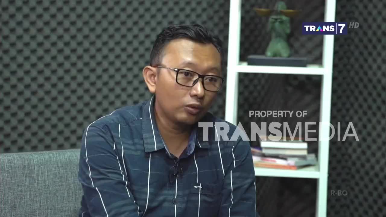 A man in glasses, wearing a striped shirt, is speaking, his mouth moving as he addresses the camera. The Trans7 logo is visible in the corner, suggesting this is a broadcast from Indonesia.
A man in glasses, wearing a striped shirt, is speaking, his mouth moving as he addresses the camera. The Trans7 logo is visible in the corner, suggesting this is a broadcast from Indonesia.