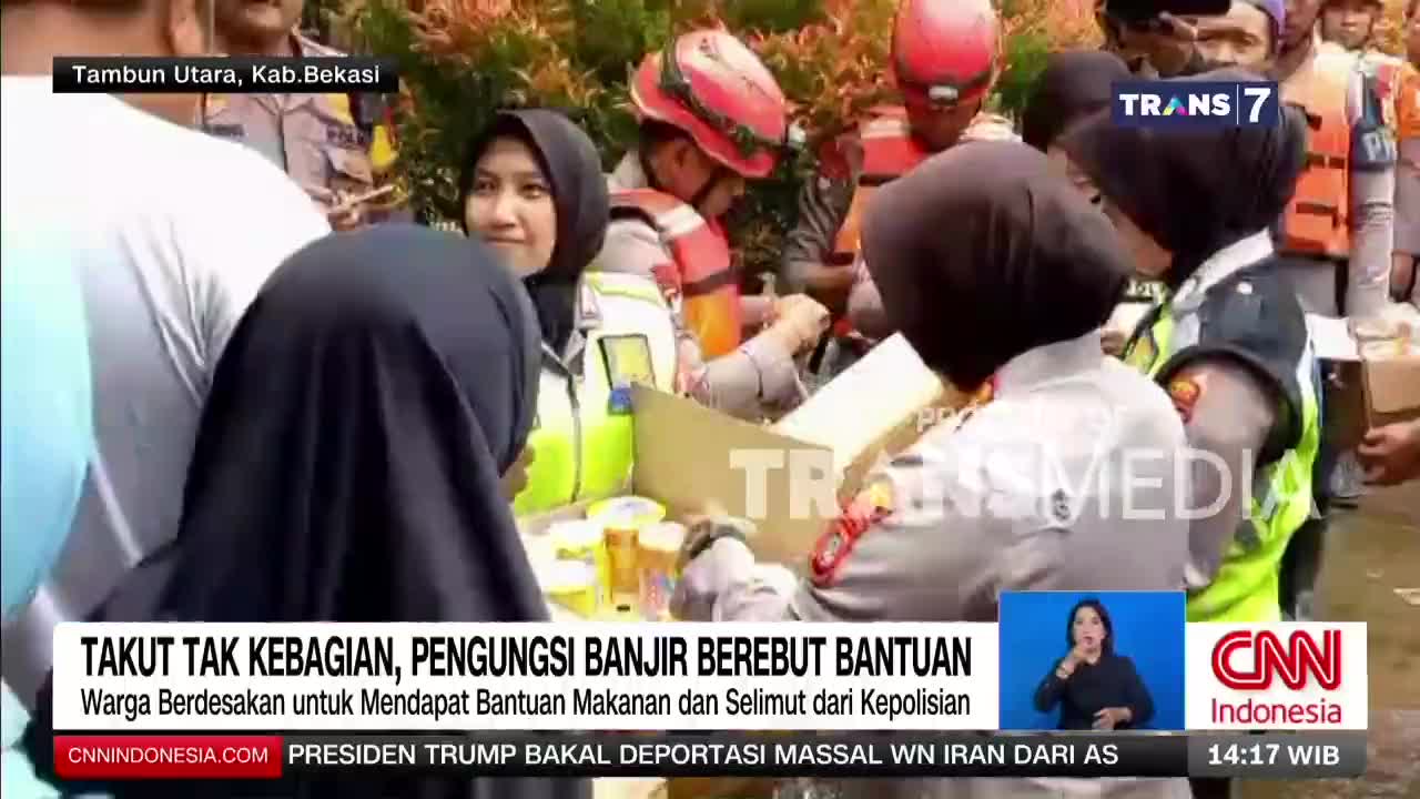 People are reaching for aid packages distributed by police officers in Tambun Utara, Kab. Bekasi. A Trans7 broadcast shows the urgency of the situation as residents scramble for supplies.
