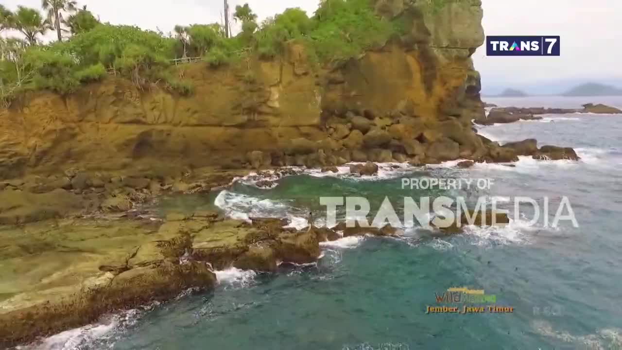 Waves crash against the rocky shore, sending white spray into the turquoise water. The Trans7 logo is visible in the upper right corner, indicating this scene is from Indonesia.