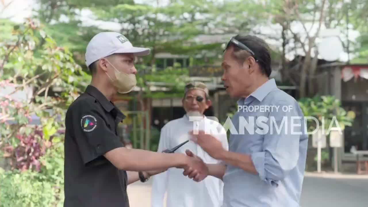 A man in a black shirt and white cap shakes hands with another man in a light blue shirt. Behind them, a third man in white observes the exchange. A man in a black shirt and white cap shakes hands with another man in a light blue shirt. Behind them, a third man in white observes the exchange.