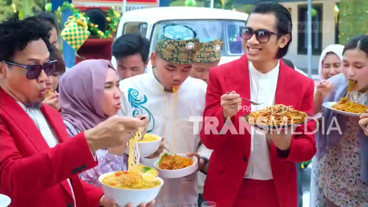 A group of people are enthusiastically eating noodles from bowls. The Trans7 logo is visible on the screen.