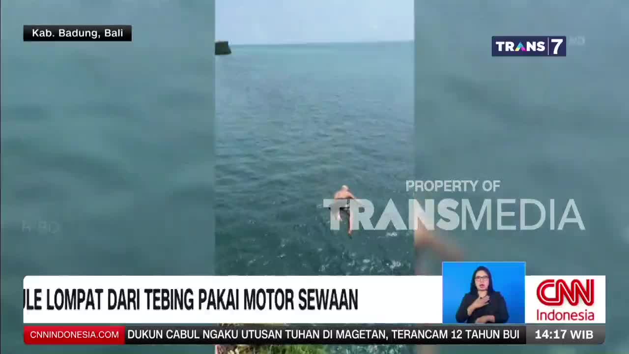 A man is launching himself off a cliff into the ocean. The Trans7 logo appears on screen, indicating this footage is from Indonesia.