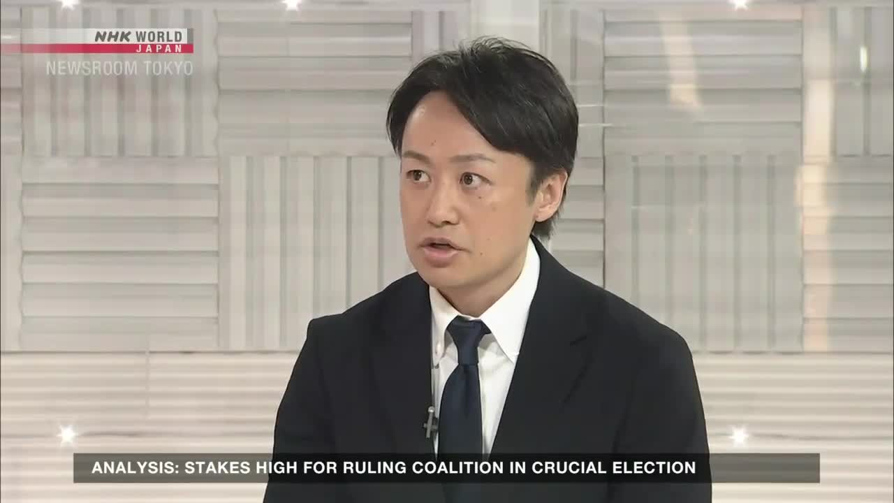 A man in a dark suit is speaking, his face lit by studio lights. The NHK World-Japan logo and "Newsroom Tokyo" are visible in the upper left corner.
