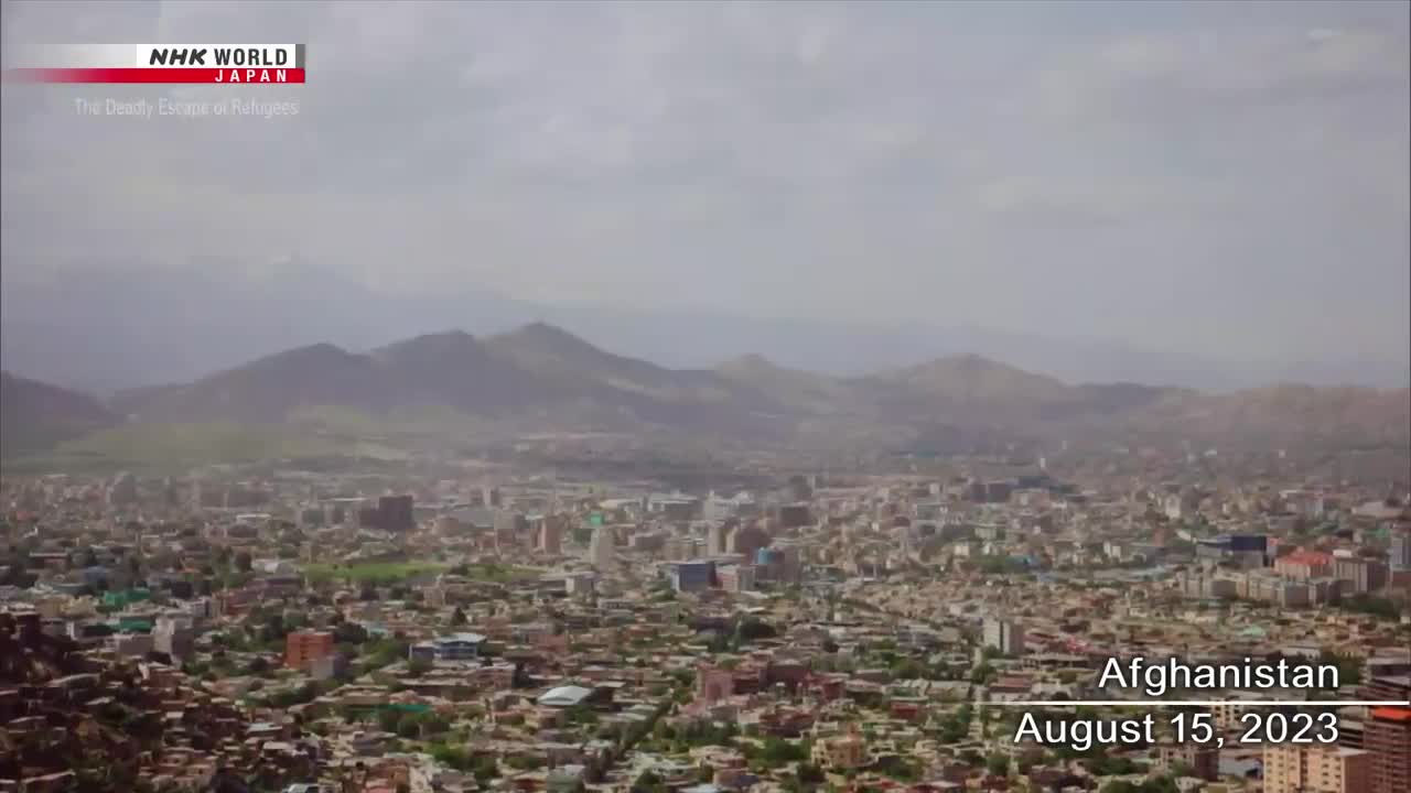 From NHK WORLD-JAPAN, I'm looking at a wide shot of a city nestled in a valley, with mountains rising in the distance under a cloudy sky. The date, August 15, 2023, is displayed over the urban landscape of Afghanistan.
