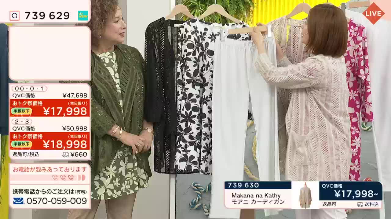 A woman in a patterned dress stands beside a rack of clothes, while another woman holds up a white cardigan. The QVC price is displayed on the screen, as the presentation continues.
