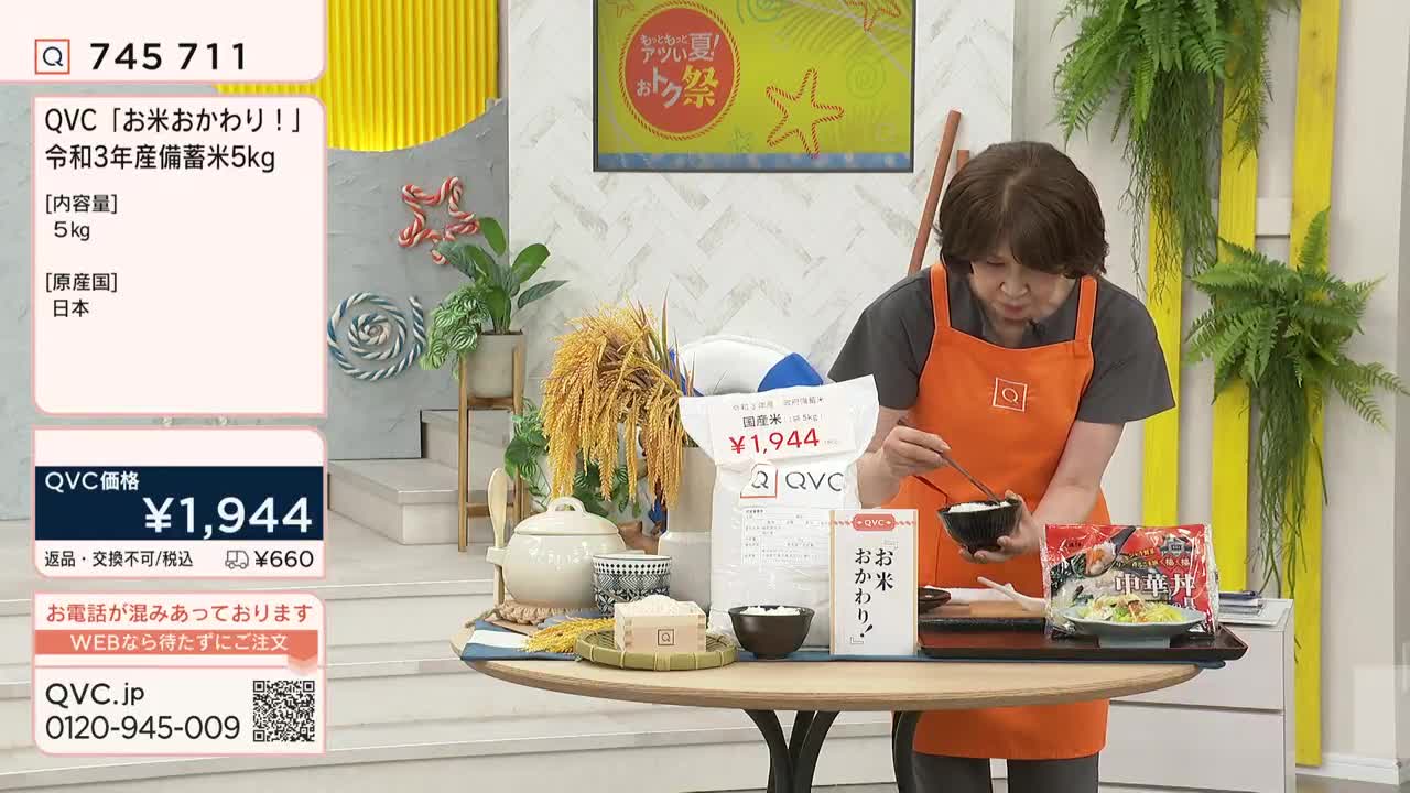 A woman in an orange apron is holding chopsticks and eating from a small bowl. The QVC Japan broadcast features a bag of rice and a display of other food items on a table.
