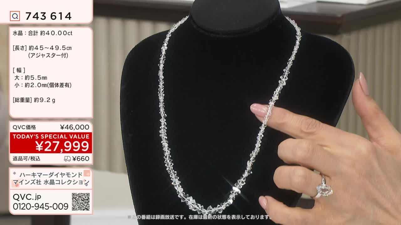 A slender, sparkling necklace of clear crystals hangs on a black bust. A hand, adorned with a ring, gently touches the beads as the price flashes on the screen in Japanese QVC.
