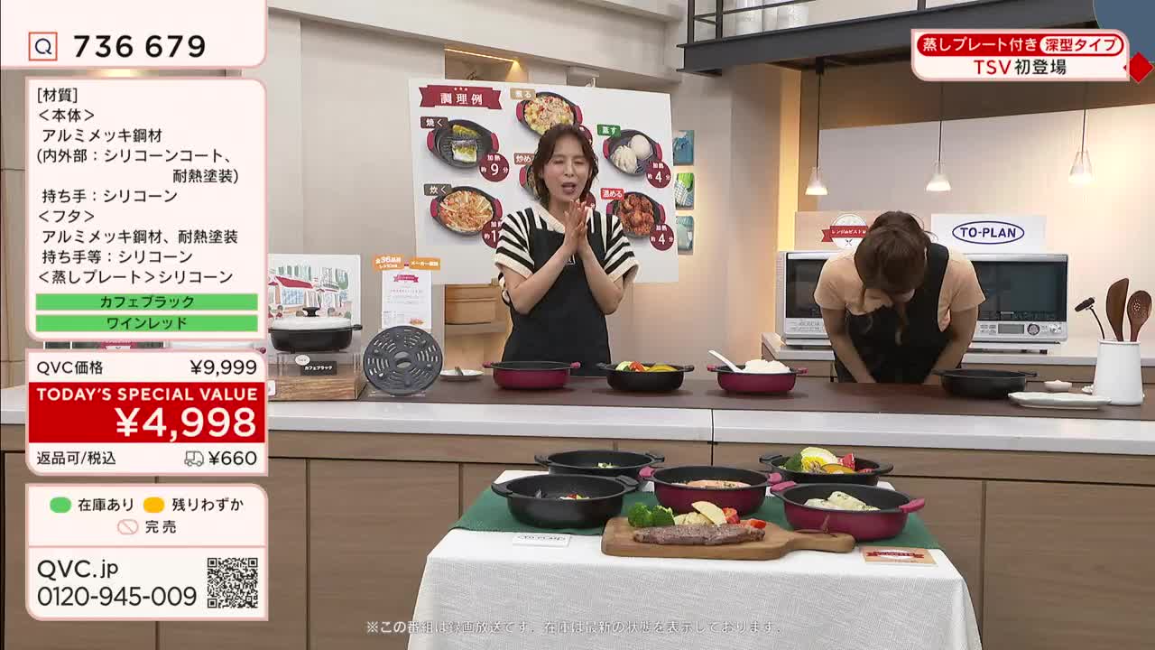 A woman in a black apron stands center, clapping her hands in front of a display of cookware. Another woman bows her head behind a counter, while the QVC logo and a special price are prominently displayed on the screen.
