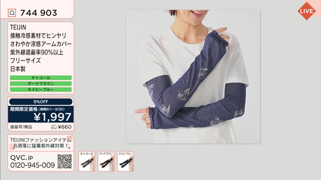 A woman in a white t-shirt models long, navy blue arm covers with floral embroidery. The QVC Japan screen shows the product details, including the price and a limited-time discount.

