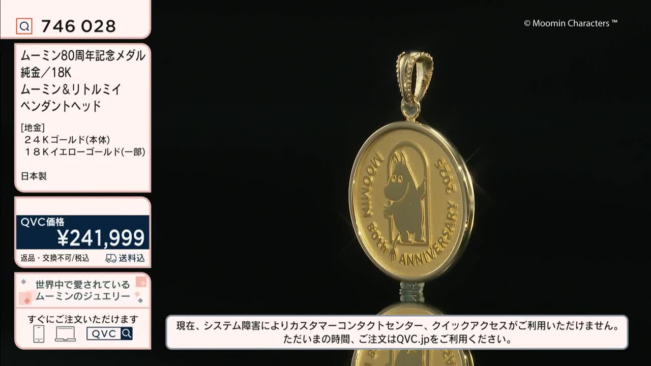 A gold pendant, featuring a cartoon character, slowly rotates on a dark surface. The price tag from QVC Japan is visible, advertising the item for over 240,000 yen.
