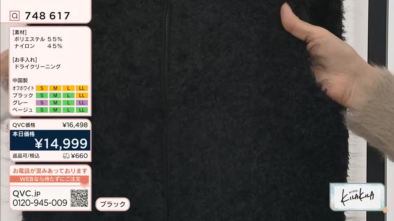 A hand gently holds up a swatch of thick, black fabric, likely for a QVC Japan presentation. The product's details, including the price and available sizes, are displayed on the screen.
