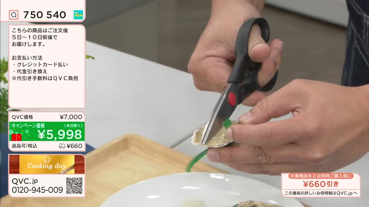A person's hands hold a pair of black scissors, snipping a green piece of something. The scene is part of a cooking demonstration on QVC Japan, where a special price is advertised.
