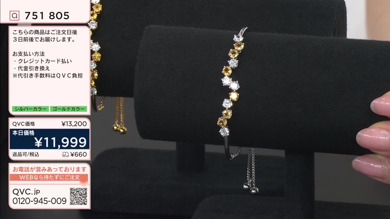 A delicate bracelet, adorned with alternating clear and amber stones, rests on a black display. Another, a gold chain with small spheres, hangs beside it. A delicate bracelet, adorned with alternating clear and amber stones, rests on a black display. Another, a gold chain with small spheres, hangs beside it.